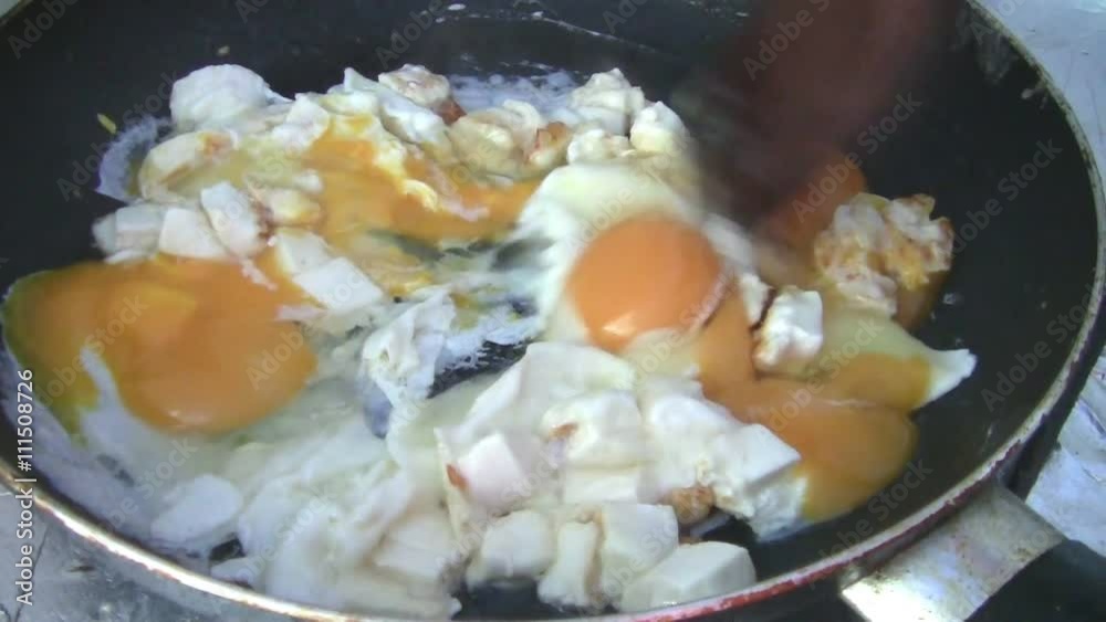 The Frittata with eggs, cheese and tomato at home. The girl with a knife slices tomatoes, cheese and breaking eggs into the frying pan. An egg-white Frittata. The Frittata with eggs, cheese and tomato at home. The girl with a knife slices tomatoes, cheese and breaking eggs into the frying pan. An egg-white Frittata.