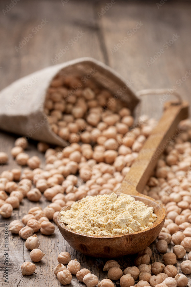 Chickpea flour in a wooden spoon Chickpea flour in a wooden spoon
