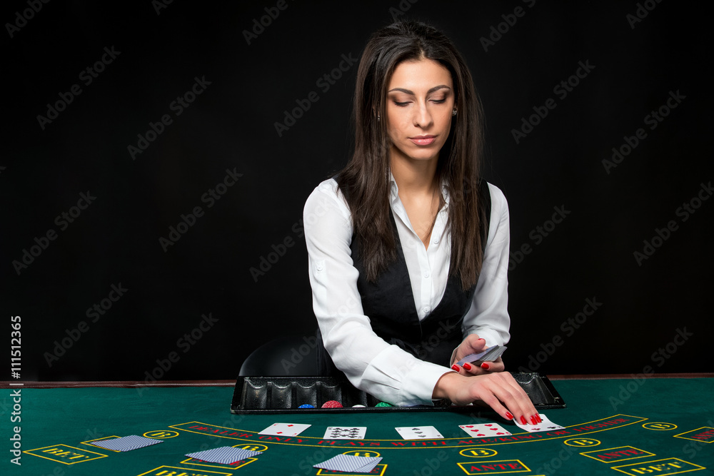 The beautiful girl, dealer, behind a table for poker The beautiful girl, dealer, behind a table for poker