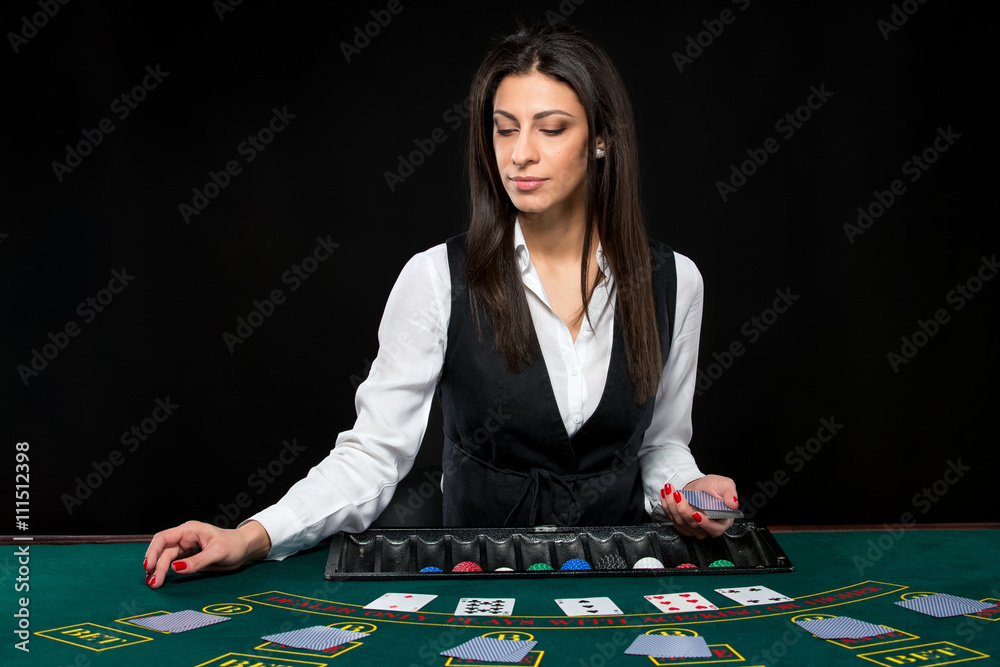 The beautiful girl, dealer, behind a table for poker The beautiful girl, dealer, behind a table for poker