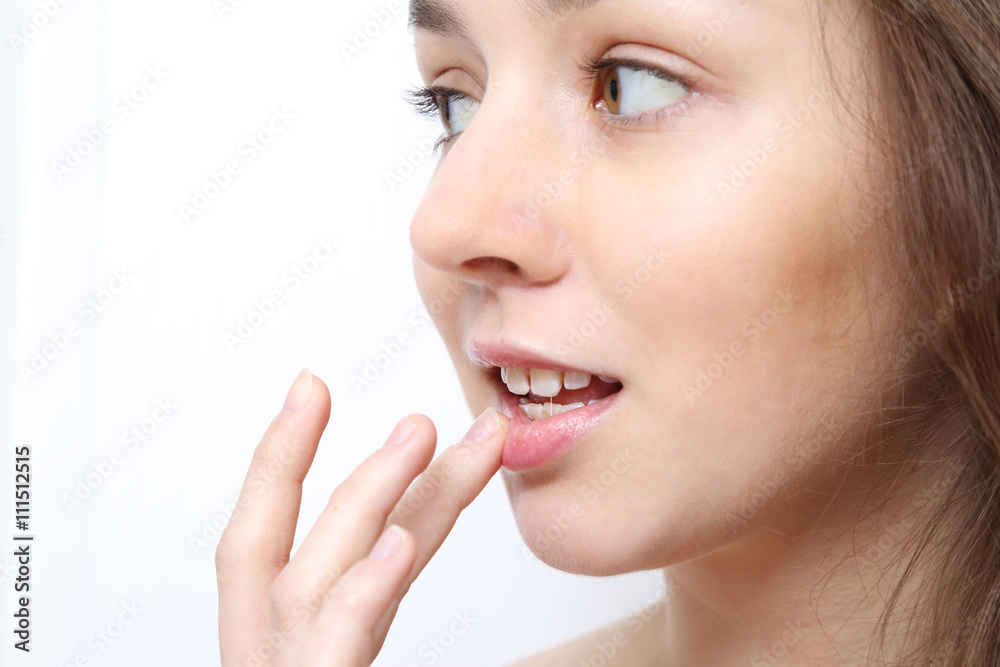 Obraz premium Nastolatka smaruje balsamem usta 