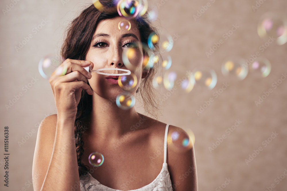 Pretty brunette blowing soap bubbles and looking at camera Pretty brunette blowing soap bubbles and looking at camera