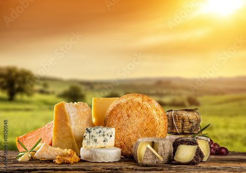 Various types of cheese placed on wooden table