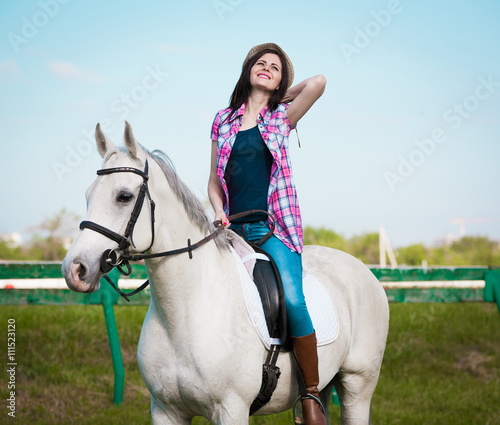 Woman sitting horse. Day. Half height. Pink plaid shirt