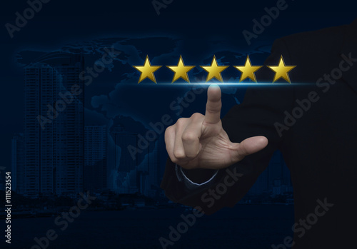 Businessman pressing five gold stars to increase rating over map photo