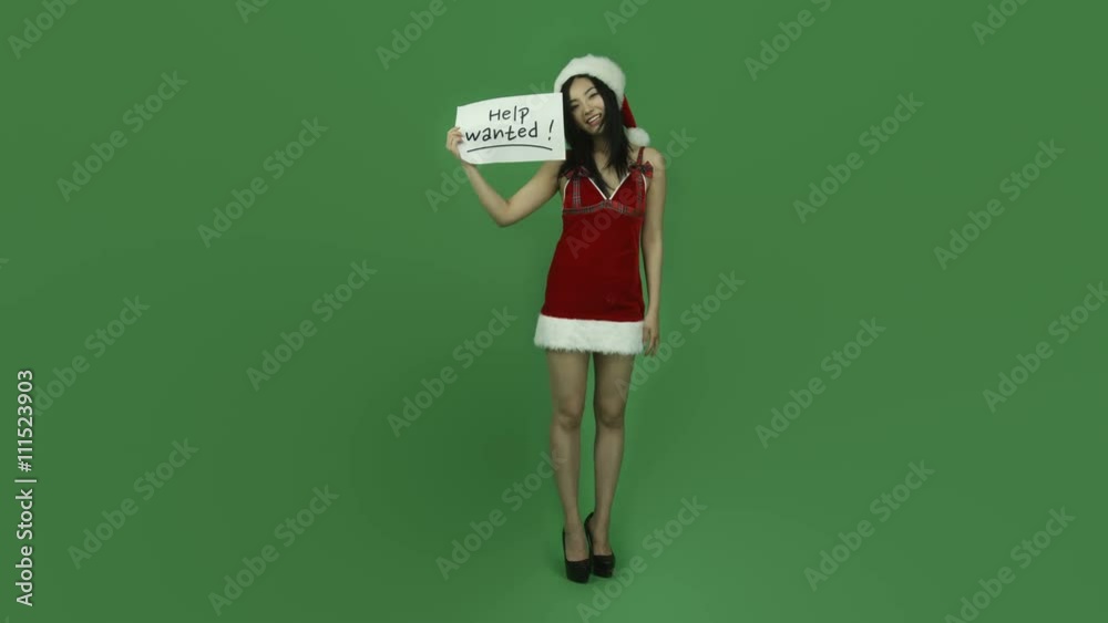 Asian girl sexy santa claus isolated greenscreen green background with help wanted sign Asian girl sexy santa claus isolated greenscreen green background with help wanted sign