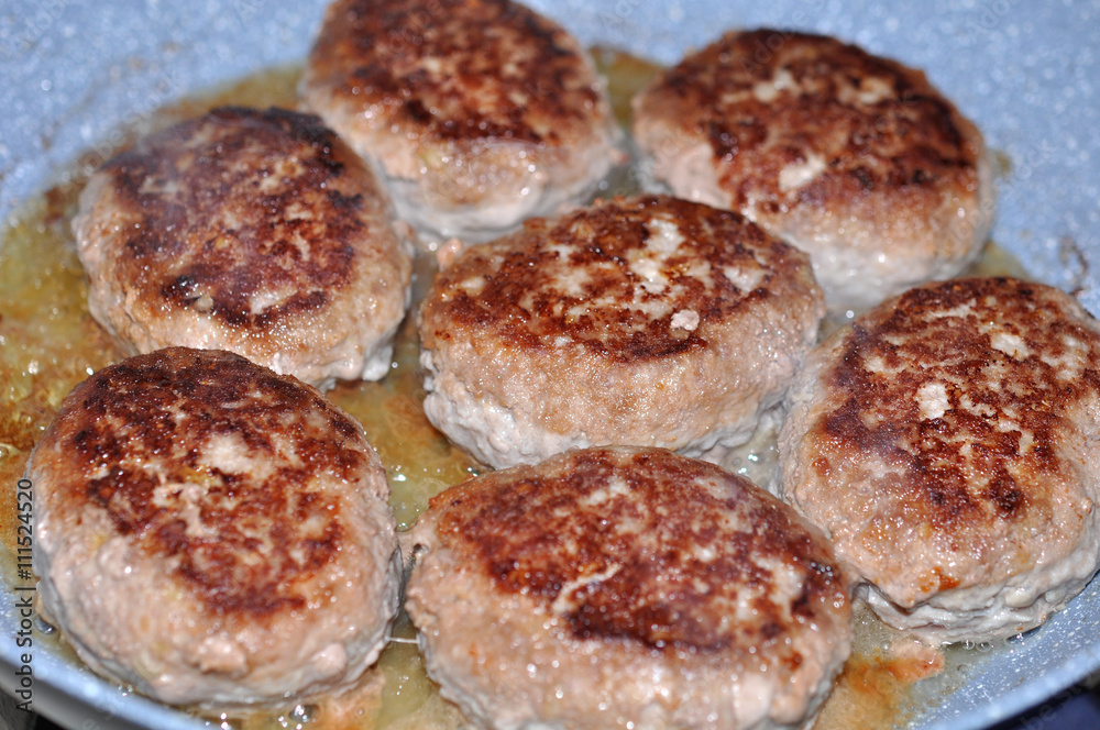 raw burgers, beef in a frying pan raw burgers, beef in a frying pan