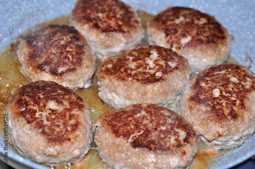 raw burgers, beef in a frying pan