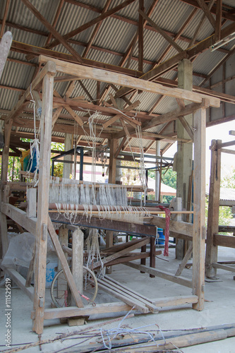 Weaving loom and shuttle on the warp.   © thirathat