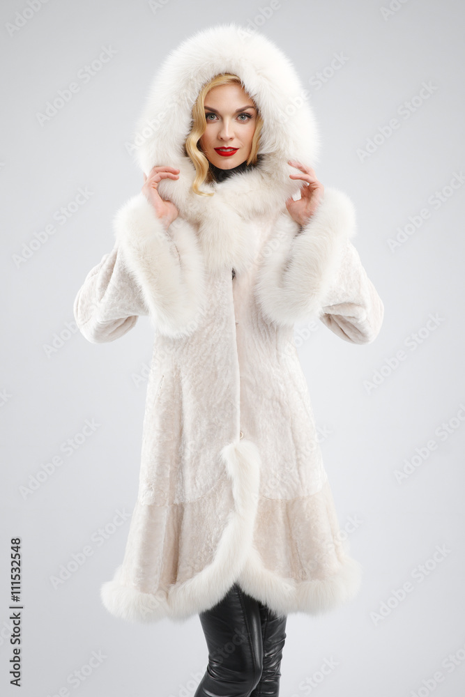 attractive lady in white fur coat with hood on head attractive lady in white fur coat with hood on head
