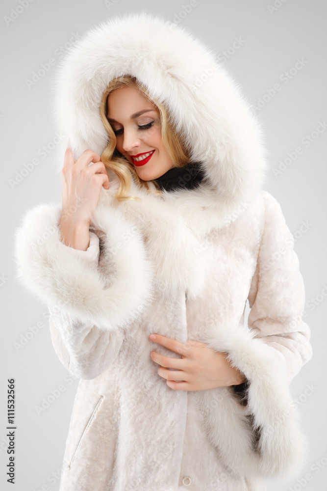 attractive lady in white fur coat with hood on head attractive lady in white fur coat with hood on head