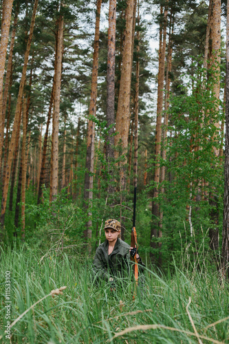 Woman hunter with a gun. Hunting in the woods. 