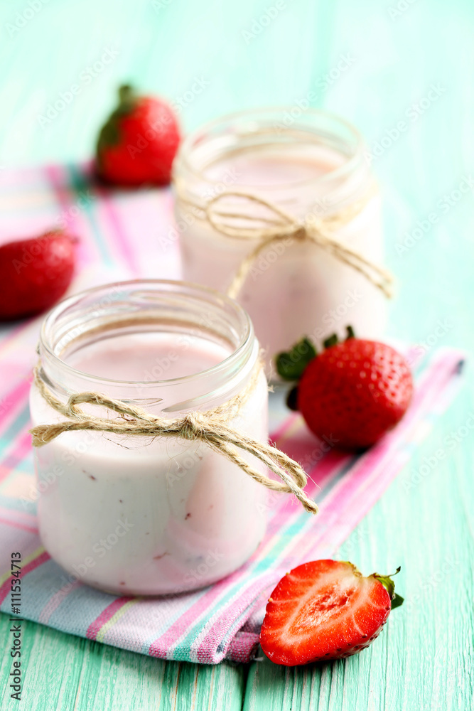 Strawberry yogurt in glass on a mint wooden table Strawberry yogurt in glass on a mint wooden table