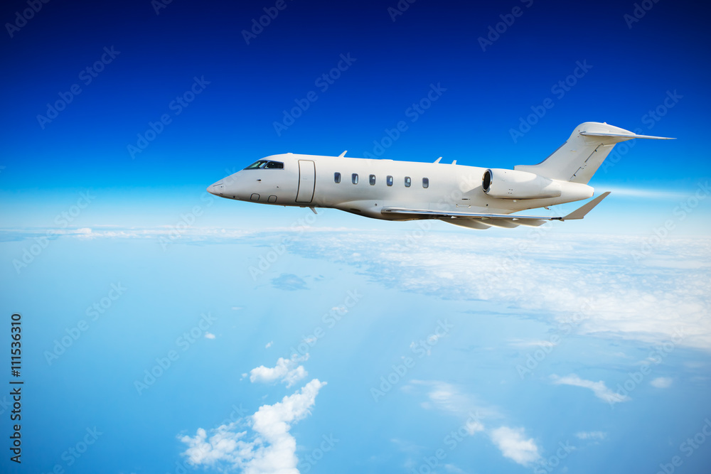 Fototapeta premium Private jet plane flying above clouds