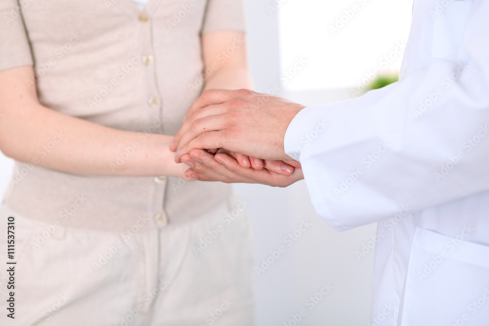 Hand of doctor reassuring her female patient
