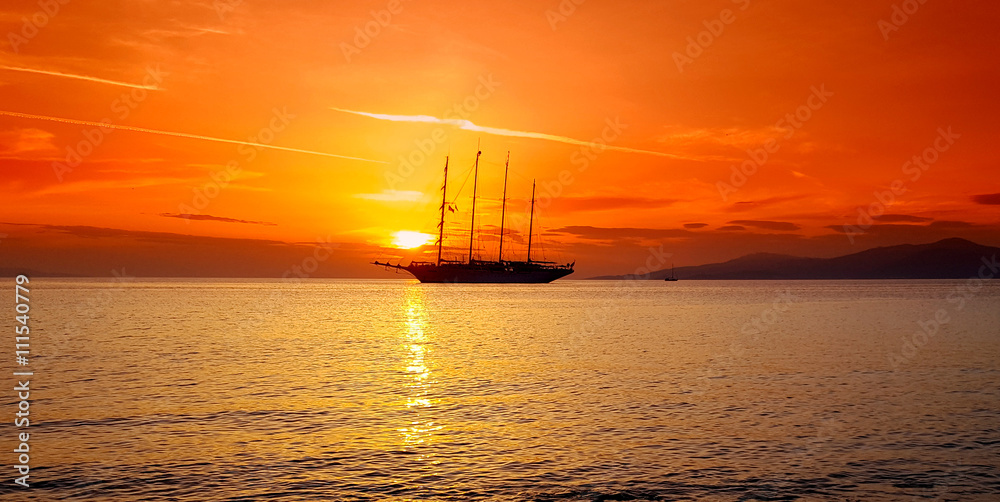 Sailing ship in the sea at sunset