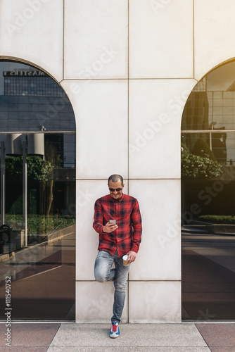 Young man using his mobile in the street.