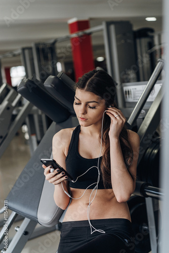 Beautiful girl with a phone in the gym