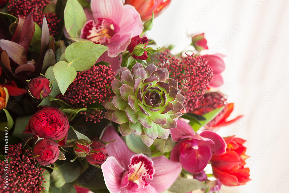 Red bright flowers with succulents in bouquet