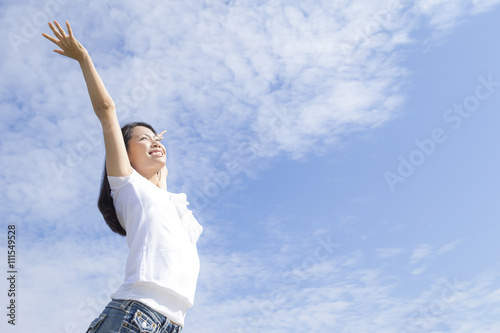 青空の下で手を広げる女性 © tsuppyinny