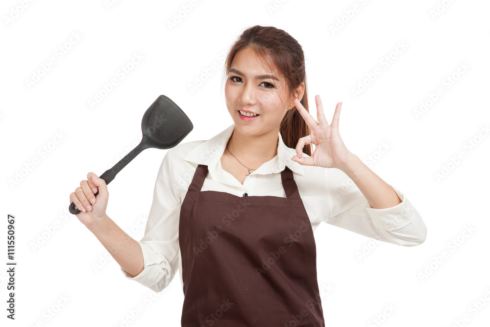 Asian beautiful girl cook show OK with spade of frying pan Asian beautiful girl cook show OK with spade of frying pan
