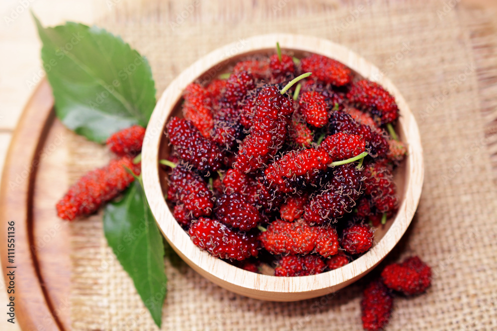 fresh organic mulberry in bowl on wooden background with mulberry fruit and mulberry branch. fresh organic mulberry in bowl on wooden background with mulberry fruit and mulberry branch.
