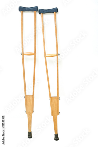 Wooden crutches rest on white wall