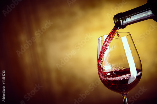 Pouring a single glass of red wine from a bottle