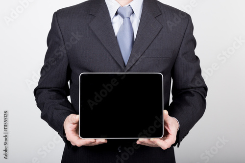 technology, internet and networking in business concept - businessman holding a tablet pc with blank dark screen. Internet technologies in business