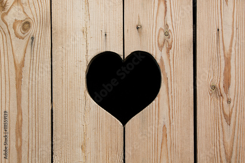 Light beige wooden background with a heart. Vintage texture. Wooden background.