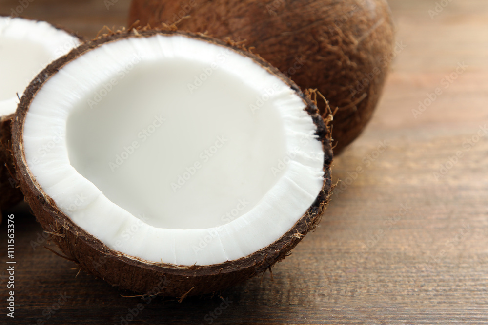 coconut cut into pieces on a brown wooden background coconut cut into pieces on a brown wooden background