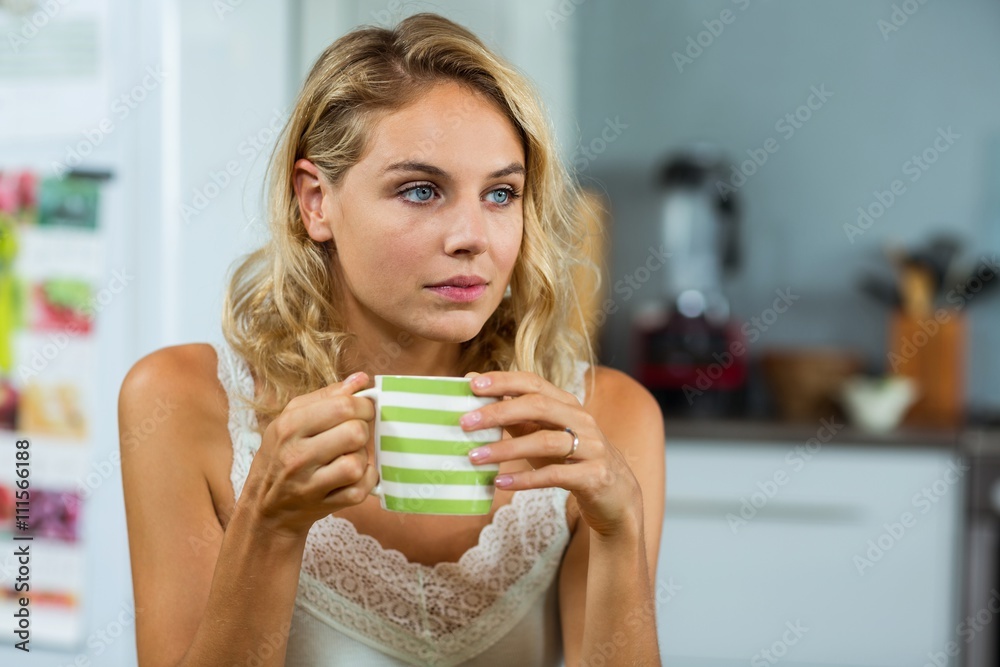 Thoughtful woman having coffee at home Thoughtful woman having coffee at home