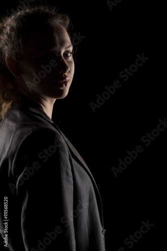portrait of a girl with the face in shadow on a dark background