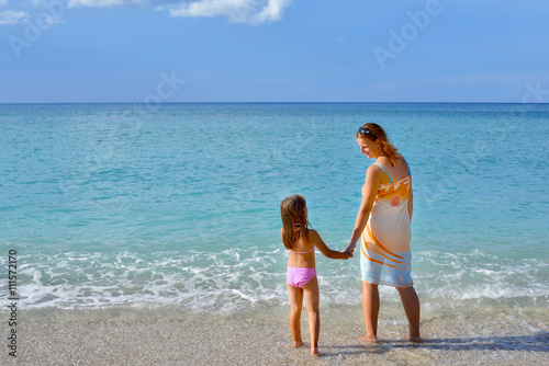 Adorable toddler girl enjoying her summer vacation at beach with