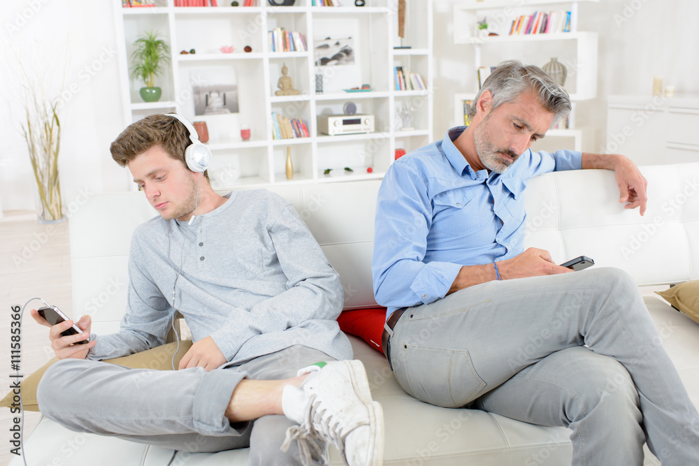 Fototapeta premium Adult and adolescent independetly using their electronic devices