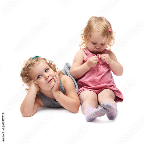 Couple of young little girl sitting over isolated white background