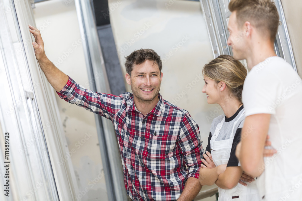 Fototapeta premium Young apprentice with professional plasterer