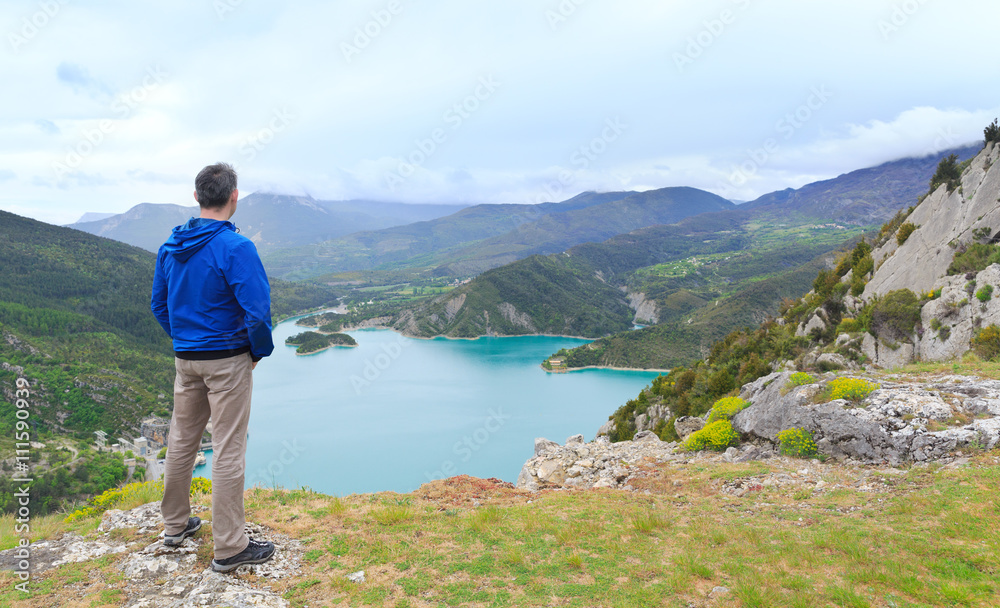 man standing on a hill and looking at a valley