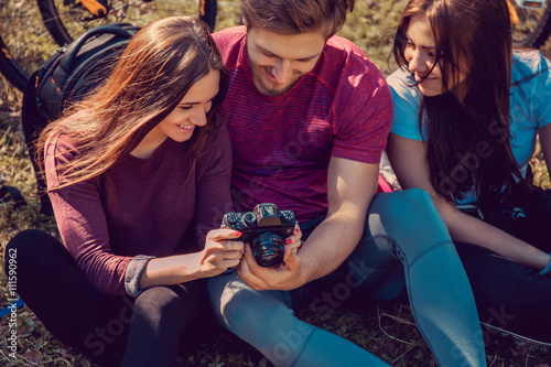 Group of cyclist taking pictures in summer forest.