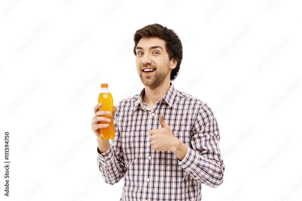 Young handsome cheerful man holding plastic bottle with orange b Young handsome cheerful man holding plastic bottle with orange b