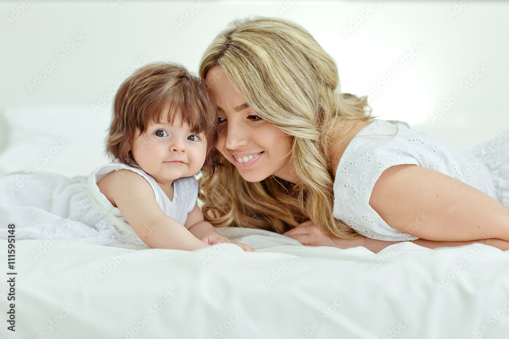 Happy mother with her funny baby on the bedroom Happy mother with her funny baby on the bedroom