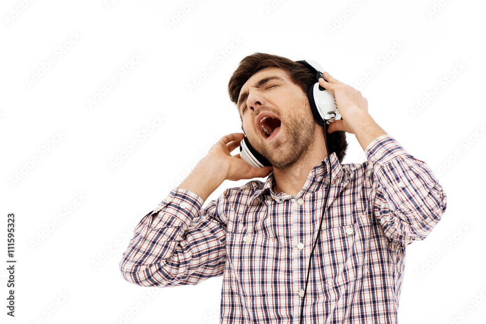 Portrait of handsome romantic young man, singing in head phones. Portrait of handsome romantic young man, singing in head phones.