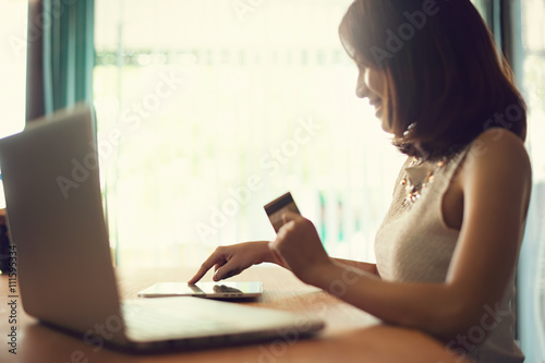 Internet of things, Shopping online, business online. Hand holding credit card doing business on line with laptop PC. Vintage filter.