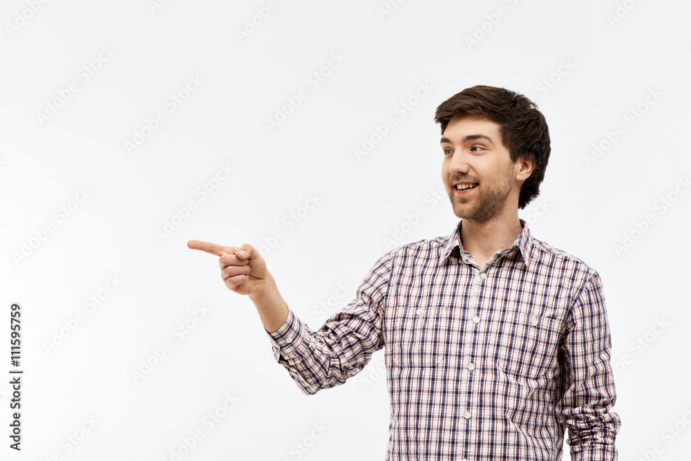 Portrait of handsome confident young man, pointing to the side, 