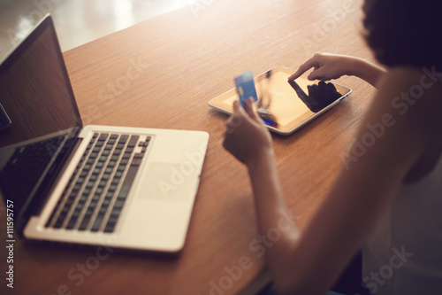 Internet of things, Shopping online, business online. Hand holding credit card doing business on line with laptop PC. Vintage filter.