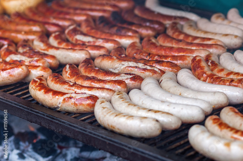 rows of bratwurst on a large grill photo