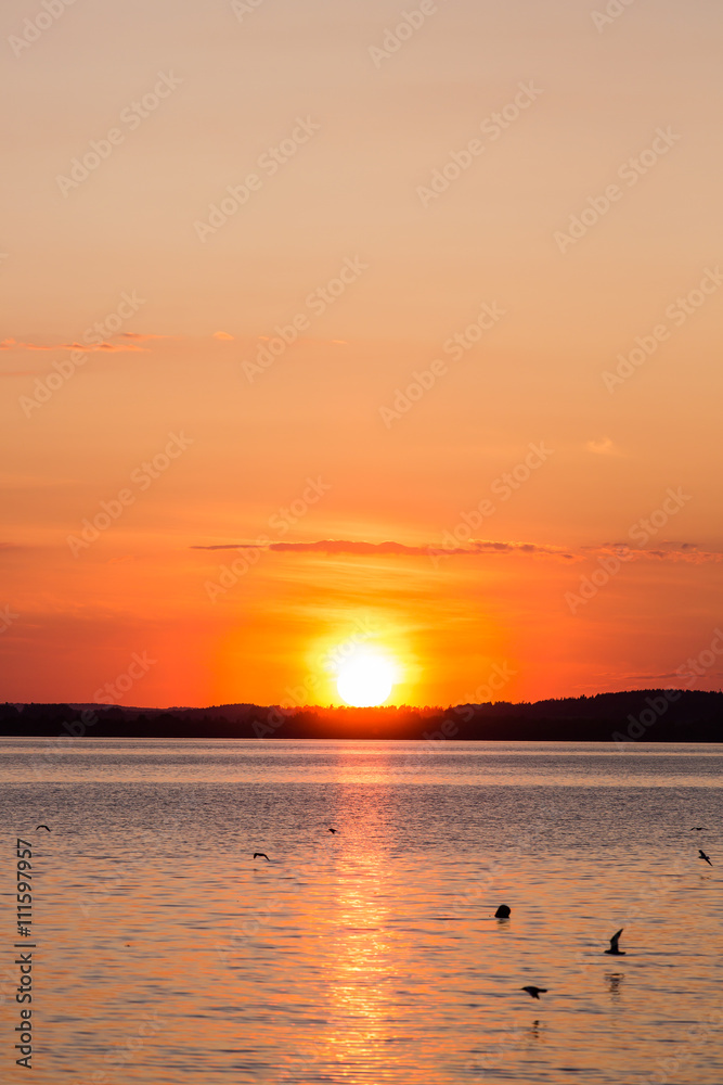 Picturesque view of a beautiful sunset over a river. Cloudy colorful sky.