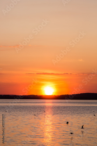 Picturesque view of a beautiful sunset over a river. Cloudy colorful sky.