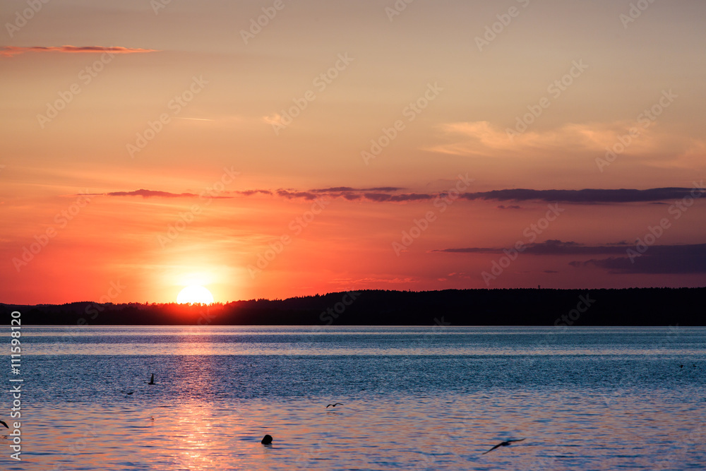 Picturesque view of a beautiful sunset over a river. Cloudy colorful sky.