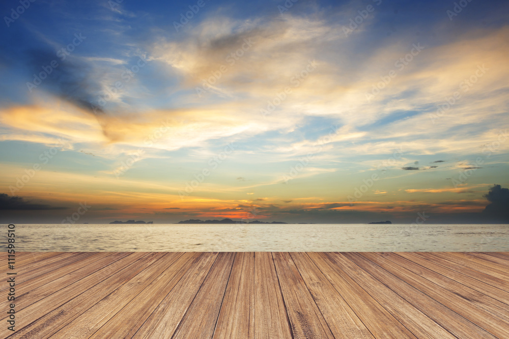 Fototapeta premium Perspective of wood terrace against beautiful seascape at sunset